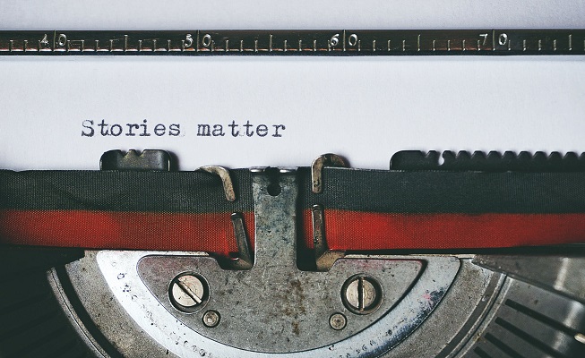 Typewriter and a piece of paper saying Stories matter